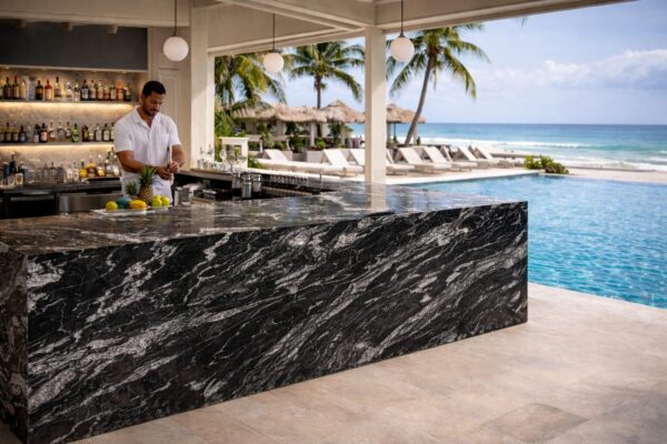Product Overview: Reliance Titanium Black & Forest Black Granite is a luxurious natural stone celebrated for its striking black background enriched with flowing golden and white veins. Mined from our owned quarry, this granite represents strength, elegance, and timeless beauty — making it a preferred choice for high-end architectural and interior projects across the globe. Each block is a unique creation of nature, offering unmatched character and visual depth. Technical Specifications: Title Reliance Titanium Black & Forest Black Granite Block Stone Type Granite Block Type Gangsaw Block Block Size 300 CM x 180 CM x 180 CM (LXWXH) Color Deep Black with Gold & White Veins Surface Finish Options Wire Saw Cut Density 2960-3000 kg/m3 Compressive Strength 200-250 MPa Water Absorption 0.2%-0.3% Hardness (Mohs) 6 to 7 Porosity Low Origin India Applications Slabs, Countertops, Flooring, Wall Cladding, Interior Key Features: Elegant Aesthetic Appeal: Deep jet-black background enhanced by golden and silver waves — a naturally luxurious look. Superior Strength & Durability: Excellent structural integrity and long-term performance in varied climates. High Polish Retention: Achieves exceptional gloss and mirror-like reflection after finishing. Consistent Texture: Uniform color and grain suitable for large-scale architectural applications. Versatile Application Range: Perfect for multiple interior purposes. Low Maintenance: Resistant to stains, scratches, and moisture, ensuring lasting beauty with minimal upkeep. Export-Grade Blocks: Carefully selected and cut for optimal slab yield and international market standards. Recommended Uses: Kitchen Countertops & Islands Luxury Flooring & Staircases Hotel Lobbies & Reception Areas Wall Cladding & Facades Memorials & Monuments Designer Furniture Tops Why Choose Reliance Titanium Black Granite and Forest Black Granite? Our granite is preferred by export buyers because of: Natural white veins and attractive deep black surface Zero crack, high strength and durability, suitable for projects & reprocessing Consistent Gang Saw block sizes Strict quality checks for each block before shipment Reliable and stable long-term supply Export Capabilities & Payment Terms: We provide smooth, professional export handling with: Payment Options: L/C at sight (Letter of Credit at sight) D/P (Documents Against Payment) T/T advance (if preferred by the buyer) Shipping Documents Provided: Bill of Lading (BL) Commercial Invoice Packing List Certificate of Origin Other documents as per buyer requirements Shipping Price Options: FOB (Indian Port) CNF (any destination port globally) Our logistics team ensures timely loading, documentation, and shipment coordination for a hassle-free experience. About Reliance Mines & Minerals We have a strong presence in the global stone industry, regularly exporting to China, Germany, USA, Oman, and Qatar . Our team is experienced in international trade procedures, ensuring professional communication and smooth cooperation with all partners. We Welcome Your Inquiry If your company is seeking a reliable supplier for premium Titanium black & Forest black granite blocks, we would be pleased to offer quotations, block photos, videos and quarry videos and further details. We look forward to establishing a long-term and successful business relationship with your esteemed company. More About Reliance Titanium Black & Forest Black Granite: Reliance Titanium Black & Forest Black Granite combines natural elegance with engineering excellence. Its bold veins and premium polish bring sophistication to any architectural space, while its robust physical properties ensure durability even in demanding environments. Each block is meticulously extracted and inspected to meet international export quality benchmarks. Reliance Mines & Minerals specializes in the sales and global export of premium granite blocks and slabs. With years of experience in the stone industry, we have established a strong presence in international markets. We are committed to delivering top-quality granite with timely and reliable shipments to major ports worldwide. Our dedicated sales and logistics team is highly skilled in managing export documentation, container loading, and shipping procedures, ensuring a smooth and hassle-free experience for our clients. At the heart of our business is a focus on excellence, professionalism, and customer satisfaction, making us a trusted partner for granite buyers around the globe. 印度 花岗岩 块料 泰坦黑 花岗岩 印度 森林黑 花岗岩 印度 印度 花岗岩 块料, 印度 出口 花岗岩 块, 印度花岗岩原石 中国进口 India granite block Titanium Black granite India Forest Black granite India Granite Blocks Titanium Black Granite Reliance Titanium Black Granite Titanium Black Granite Slabs Polished Titanium Black Granite Bookmatch Titanium Black Granite Titanium Black Granite Exporters India Titanium Black Granite Suppliers Titanium Black Granite Manufacturers Exotic Black Granite with White Veins Deep Black Granite Slabs Mirror Polished Granite Luxury Granite for Interior Walls Natural Stone for Modern Architecture High Gloss Granite Panels Bookmatched Granite Wall Design Black Granite for Hotel Lobby & Flooring Designer Granite Slabs for Projects Indian Granite Exporters Premium Granite from India Granite Slabs for Export Worldwide Granite Supplier Natural Stone Exporter from India Wholesale Granite Supplier Black Granite for Construction & Interiors Architectural Granite Stone Supplier Custom Cut Granite Slabs Export Granite for Wall Cladding Granite for Flooring Granite for Kitchen Countertops Granite for Hotel & Commercial Projects Interior Stone Cladding Luxury Stone for Architects & Designers Black Forest Granite supplier Black Forest Granite manufacturer Black Forest Granite exporter Black Forest Granite quarry Black Forest Granite wholesaler Black Forest Granite seller Buy Black Forest Granite blocks Buy Black Forest Granite slabs Black Forest Granite for flooring Black Forest Granite for countertops Black Forest Granite for wall cladding Black Forest Granite price per sqm Black Forest Granite bulk supplier Black Forest Granite block exporter Black Forest Granite slab manufacturer Black Forest Granite quarry owner Black Forest Granite wholesale price Black Forest Granite large quantity supplier Black Forest Granite custom sizes Black Forest Granite supplier India Black Forest Granite manufacturer India Black Forest Granite exporter India Black Forest Granite quarry India Black Forest Granite supplier [Your City/State] Black Forest Granite international exporter Premium Black Forest Granite supplier Natural Black Forest Granite stone High quality Black Forest Granite slabs Black Forest Granite direct from quarry Black Forest Granite blocks for export Black Forest Granite polished slabs Black granite stone supplier Natural granite stone exporter Indian black granite manufacturer Granite blocks and slabs exporter Dimension stone granite supplier Nebula Wave Granite Stone Manufacturer Export Quality Blocks Supplier Quarry Reliance Mines India Titanium Black Granite Stone Manufacturer Export Quality Blocks Supplier Quarry Reliance Mines India Cosmic Black Granite Stone Manufacturer Export Quality Blocks Supplier Quarry Reliance Mines India Marquina Black Granite Stone Manufacturer Export Quality Blocks Supplier Quarry Reliance Mines India Black Forest Granite Stone Manufacturer Export Quality Blocks Supplier Quarry Reliance Mines India #TitaniumBlackGranite #RelianceGranite #IndianGranite #GraniteExporter #LuxuryGranite #GraniteSupplier #BlackGranite #NaturalStoneIndia #GraniteSlabs #GraniteBookmatch #InteriorDesignStone #ArchitecturalStone #PremiumGranite #GraniteExport #GraniteDesigns #reliancemines #granite #marble #stone #quarry #forestblackgranite