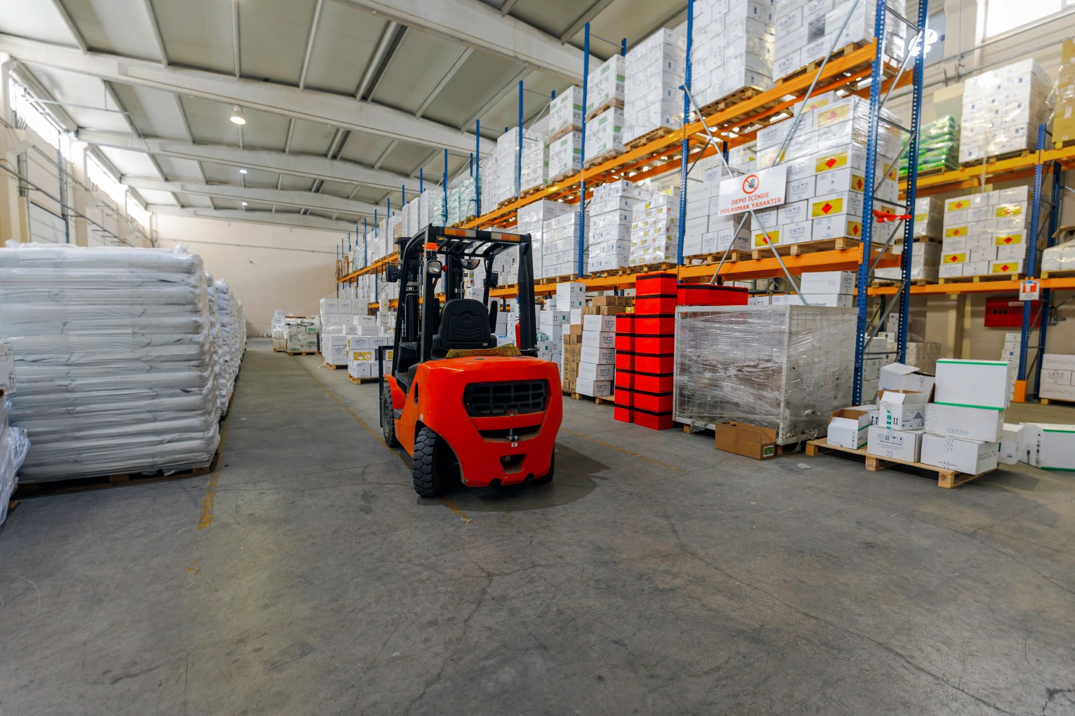 Warehouse logistics area with forklift and stacked goods